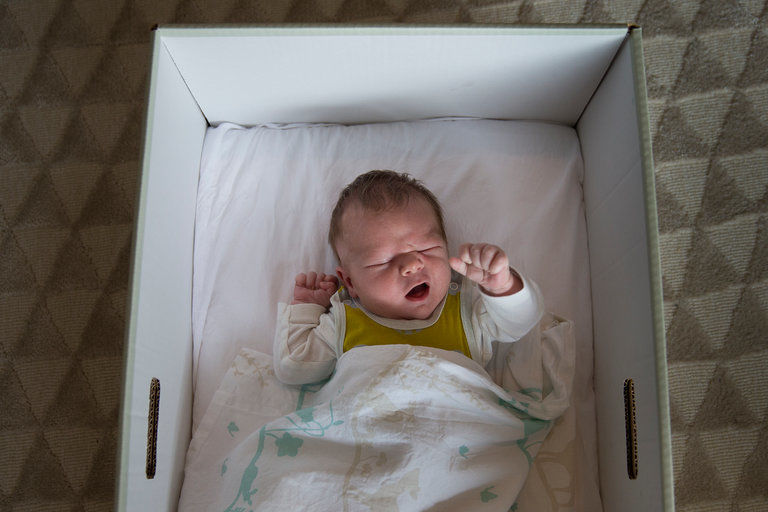 Bebelus in cutie din carton